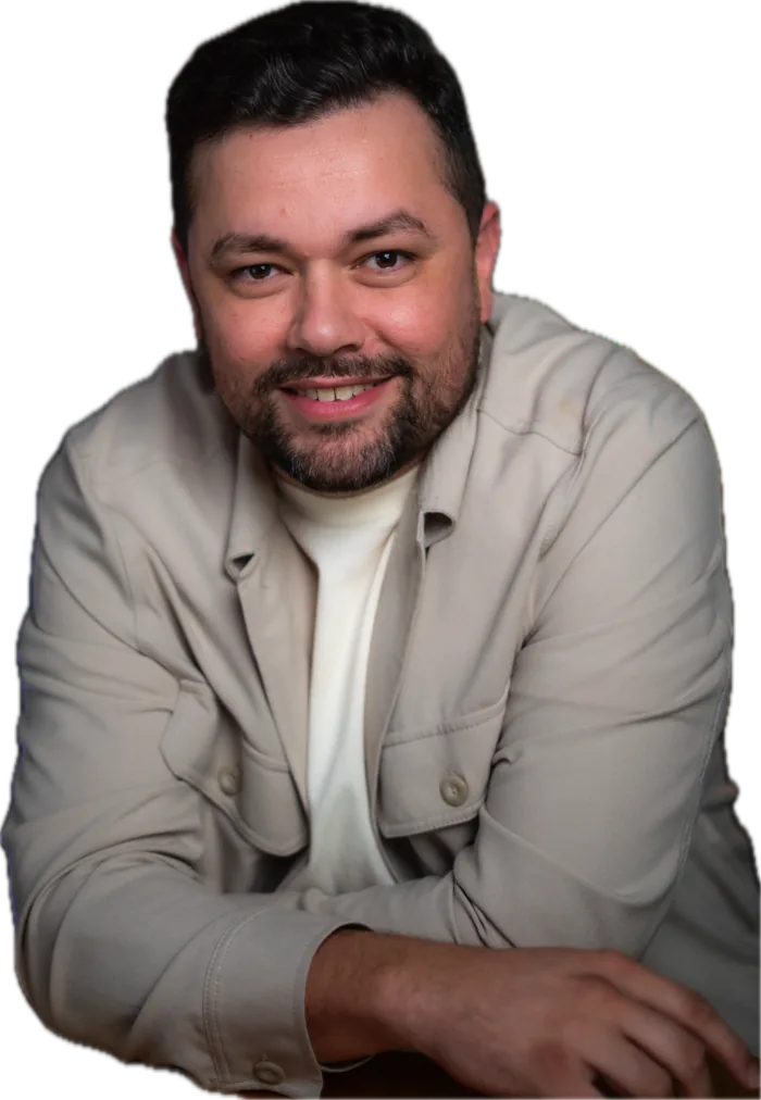 Juvenal Valentim sorrindo, apoiado numa mesa